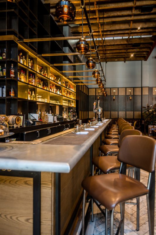 Custom bar millwork integrating plumbing, lighting, and finish carpentry requires trade coordination from rough-in through final install