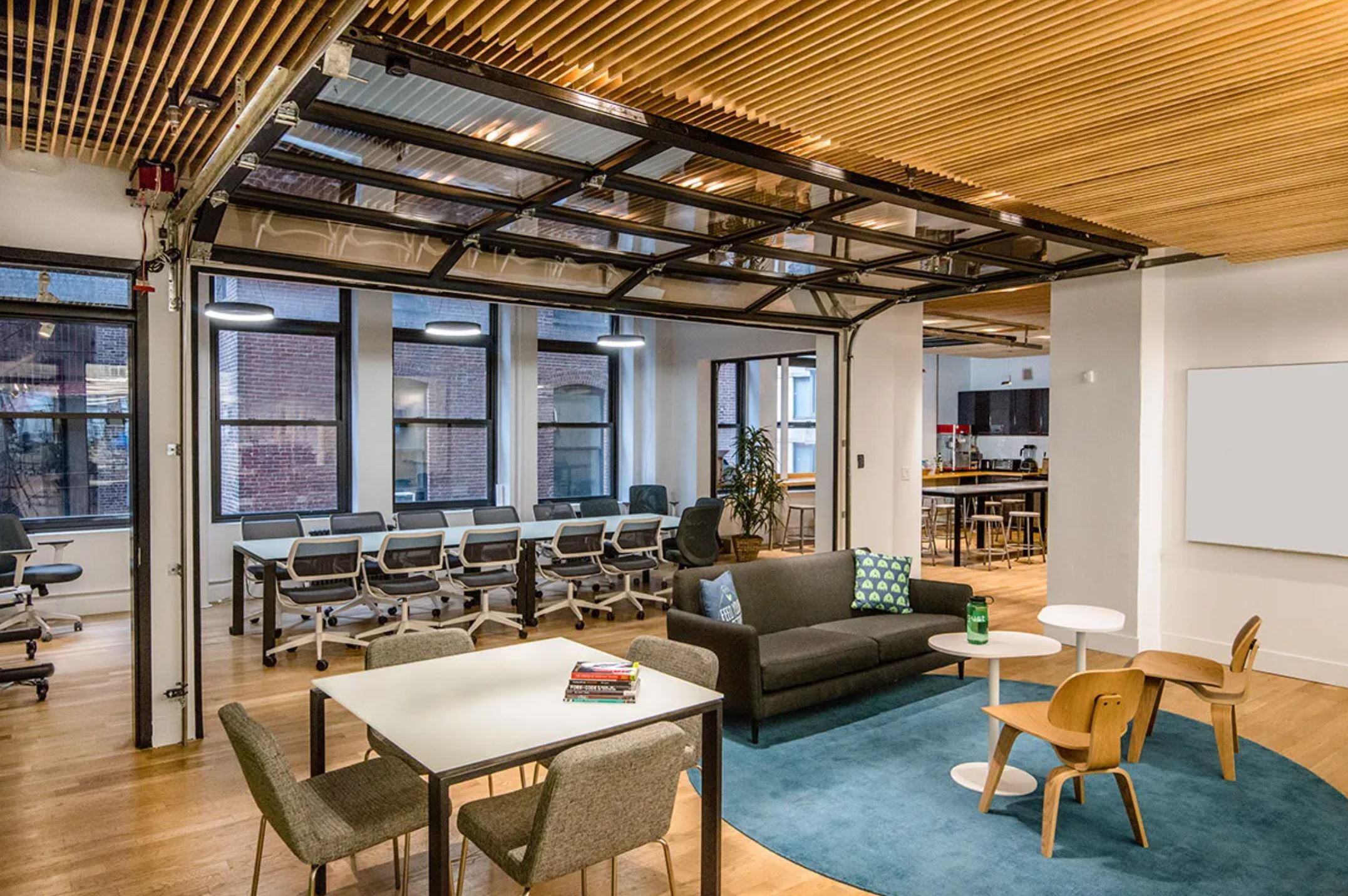 Gust office with a wood slat ceiling and a garage door between rooms