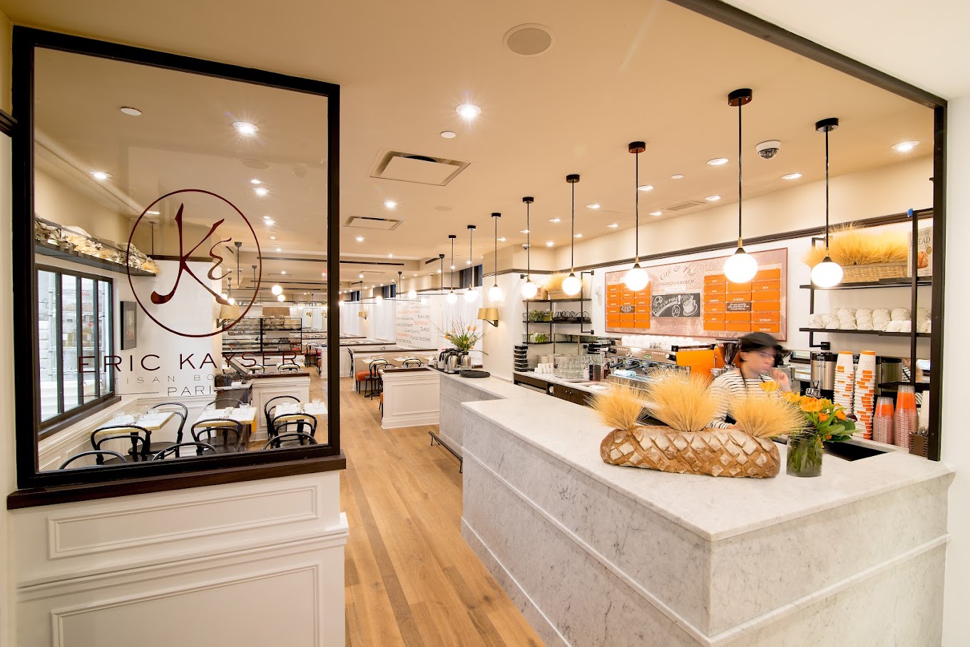 Maison Kayser bakery counter with marble surfaces and wheat sheaf decor