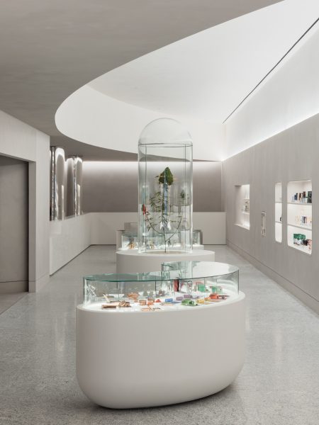 Sleek retail floor with curved ceiling and oval glass display cases